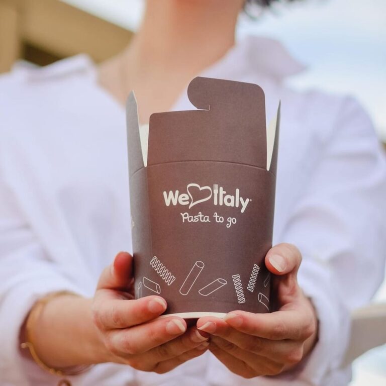 Hand holding pasta to go box